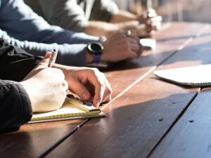 hands with pencils at wooden table