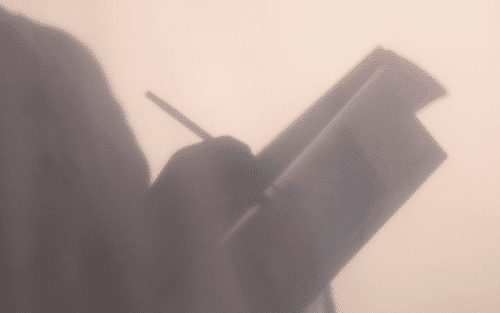 silhouette of person writing in notebook