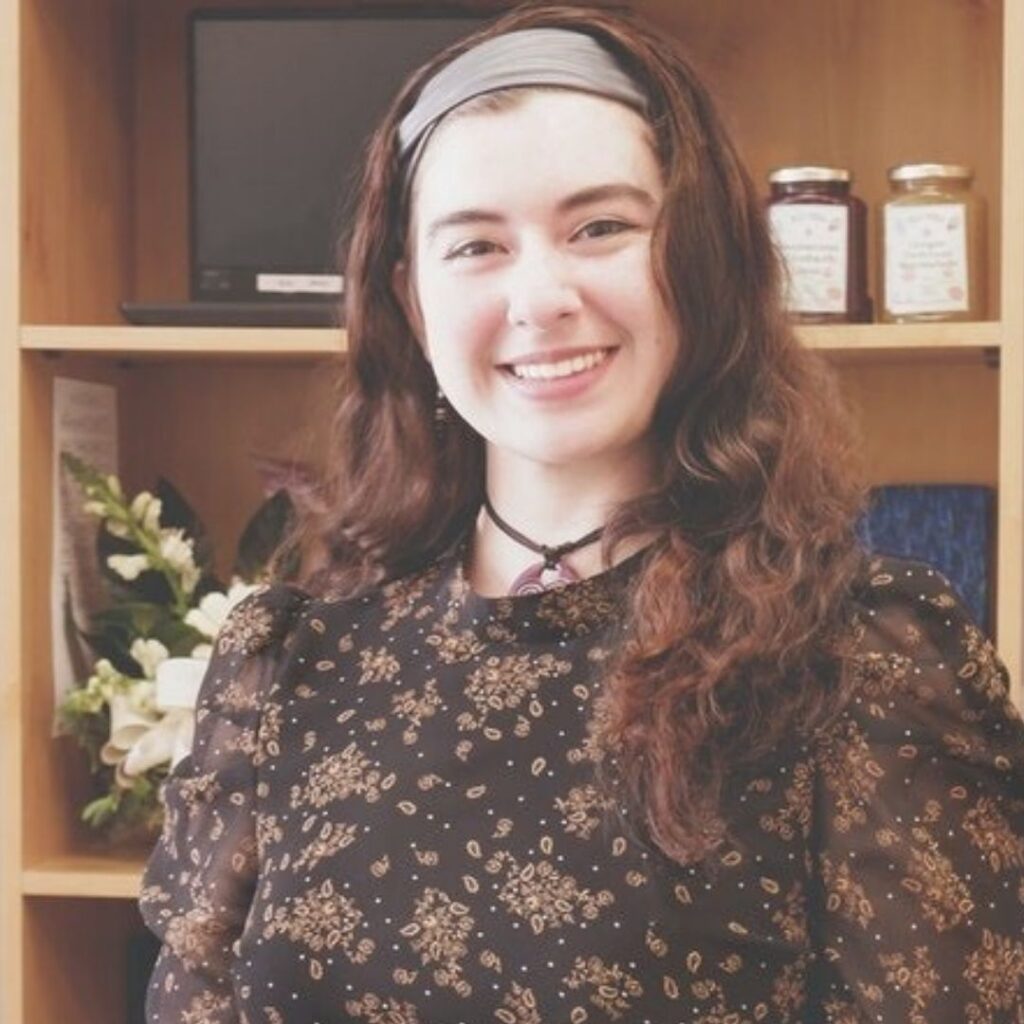 Photo of woman with long hair in front of shelves