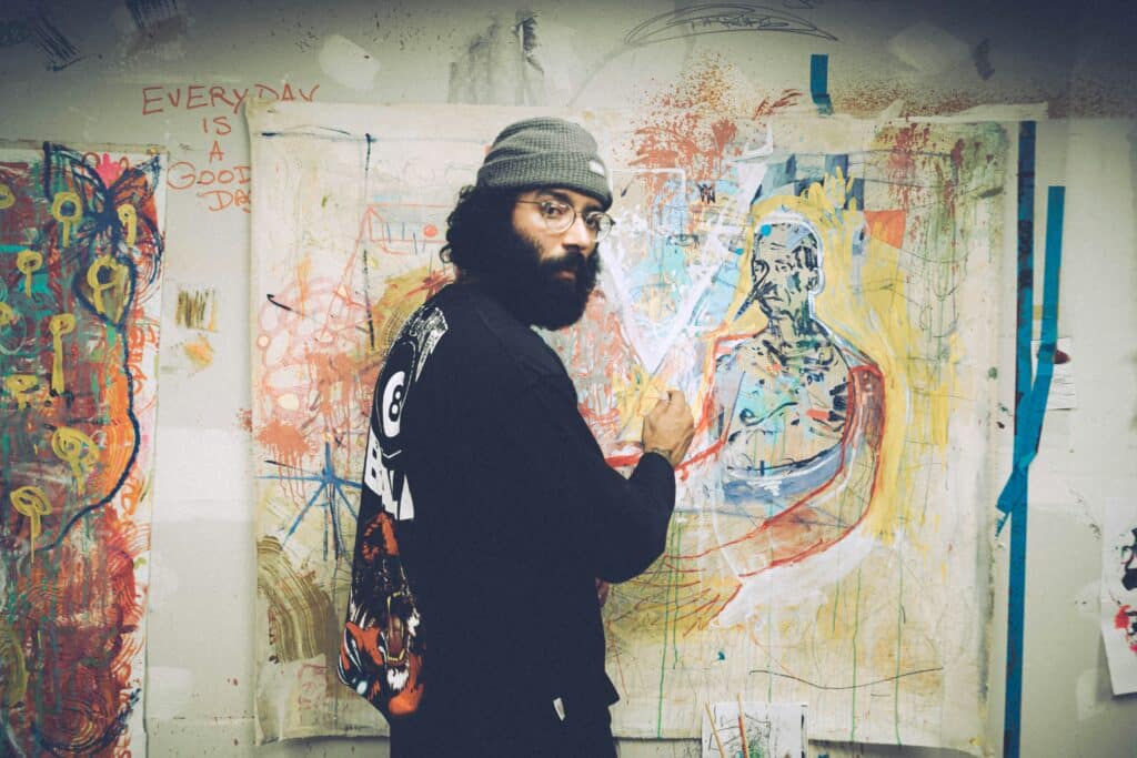 stock photo of bearded artist painting on canvas