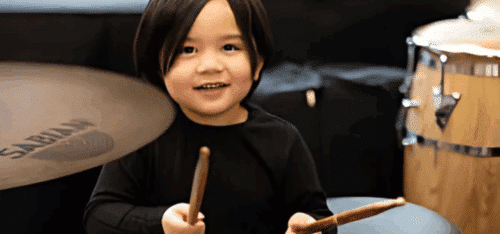 Small child holding drumsticks