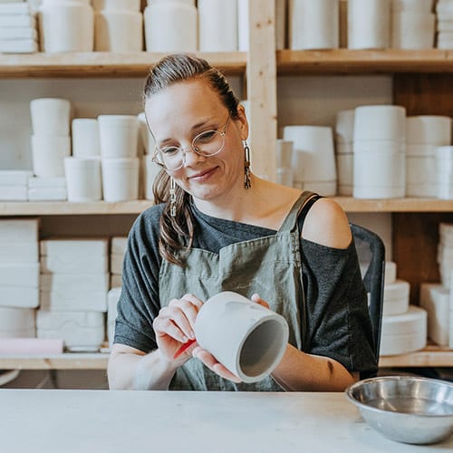 Woman in pottery studio holding ceramic pot