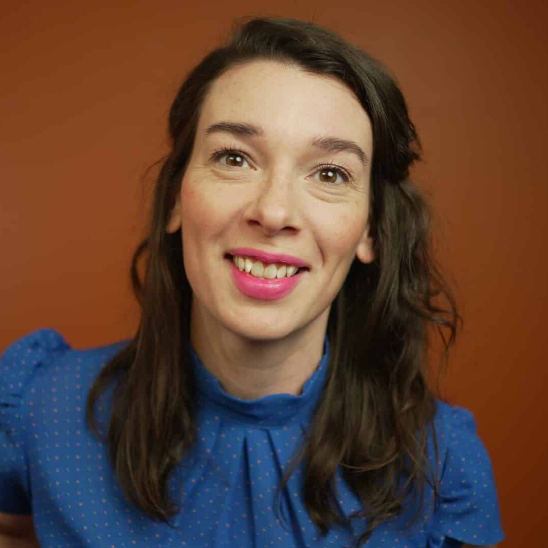Woman with long dark hair facing camera and smiling